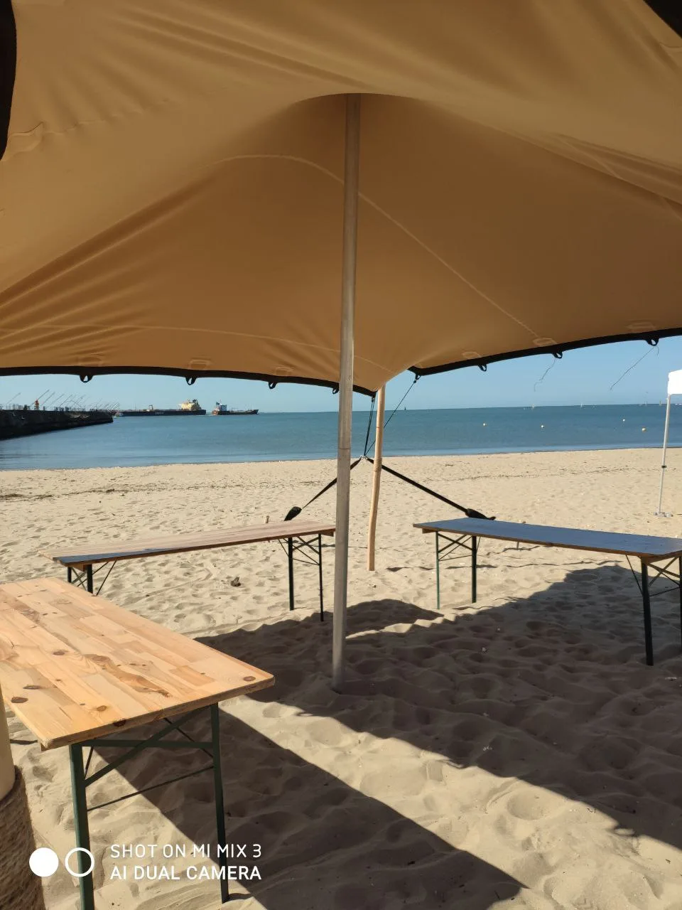 Tente stretch installée avec poteaux bois sur site naturel