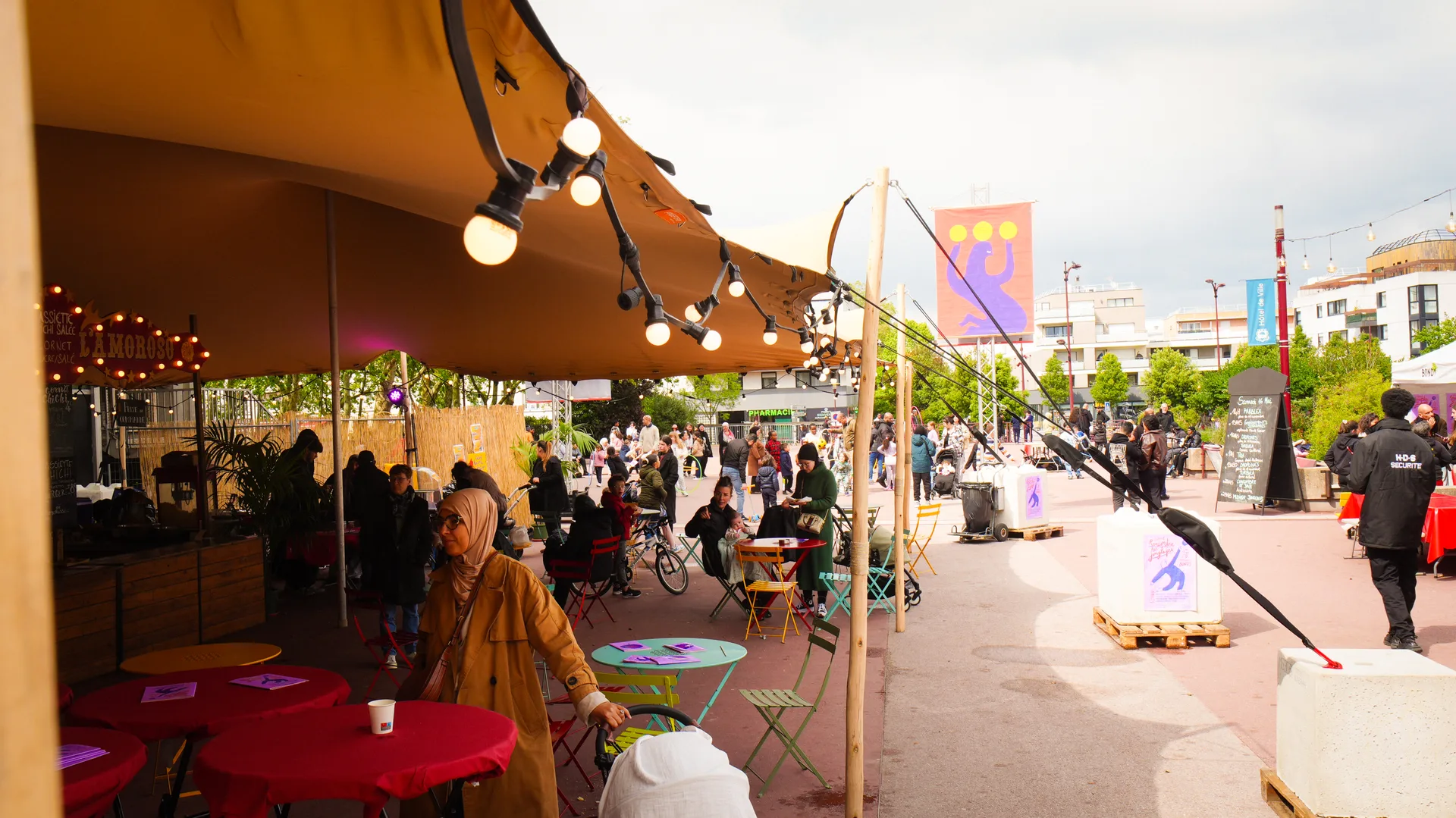 Tente stretch éclairée lors d'un événement festif avec public et guirlandes lumineuses